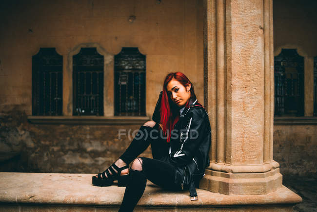 Femme assise sur une vieille galerie de pierre — Photo de stock