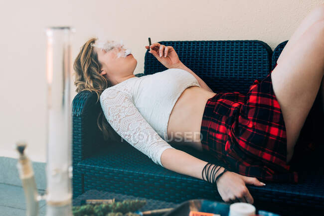 Jovem mulher fumando um charro cannabis — Fotografia de Stock
