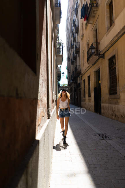Mujer funky caminando en la calle pavimentada - foto de stock