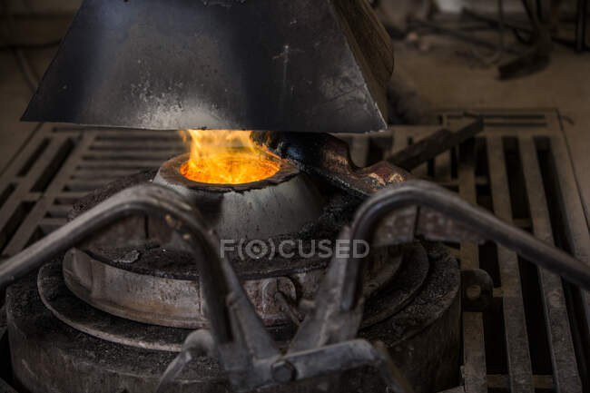 Vista de la cosecha del horno herrero con un fuego ardiente en la fábrica de fundición de metal - foto de stock