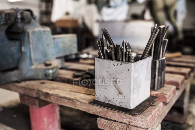 Vista da colheita de martelo e instrumentos em mesa metalúrgica de madeira — Fotografia de Stock