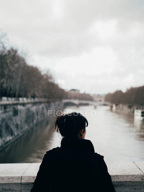 Жінка дивиться на річку з мосту — стокове фото