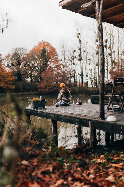Femme assise et tricot à l'étang — Photo de stock