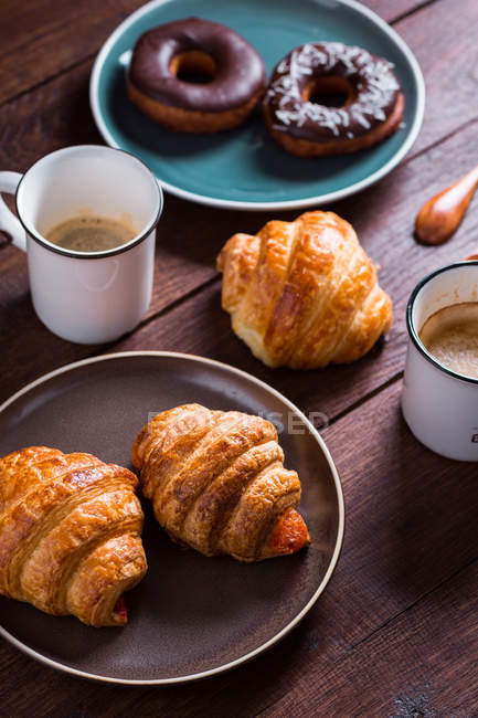 Cups of coffee and fresh croissant with donuts — Stock Photo