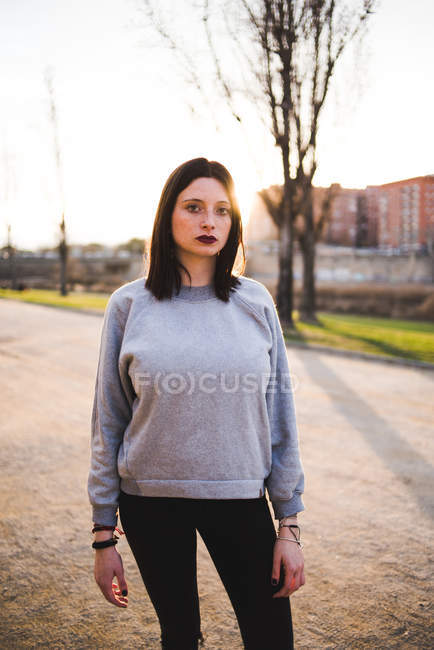 Женщина в толстовке стоит на улице — стоковое фото