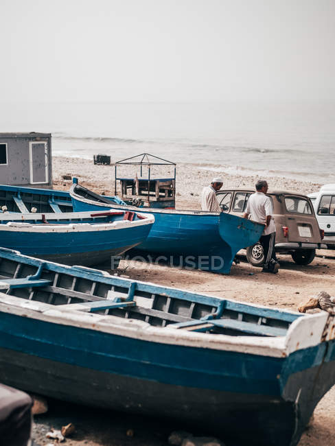 Старые синие лодки на берегу — стоковое фото