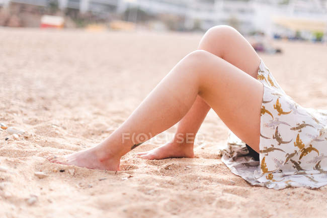 Female legs on sandy beach — Stock Photo