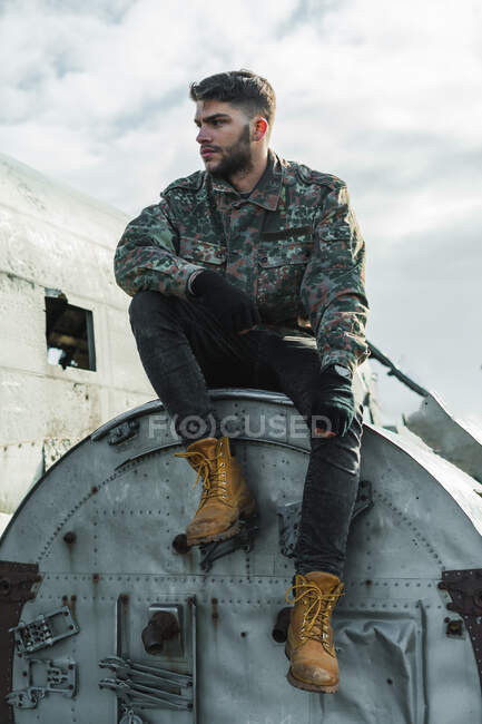 Mann sitzt auf Flugzeug-Kadaver — Stockfoto