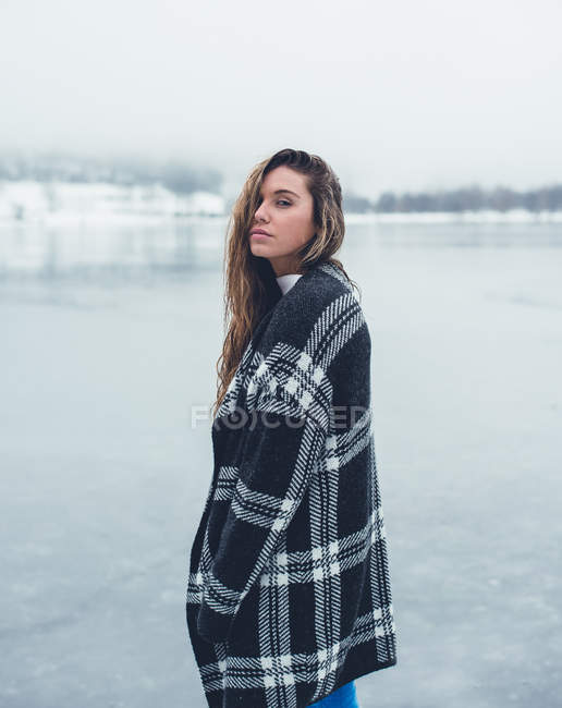 Frau steht am zugefrorenen See — Stockfoto