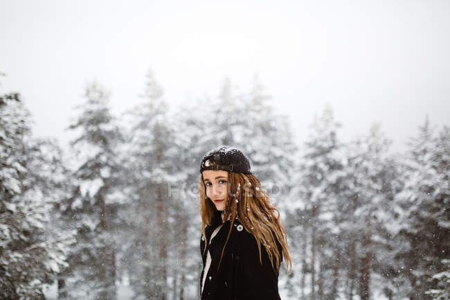 Mujer de pie en el camino nevado - foto de stock