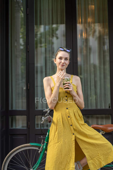 Femme debout avec vélo vintage sur la rue — Photo de stock