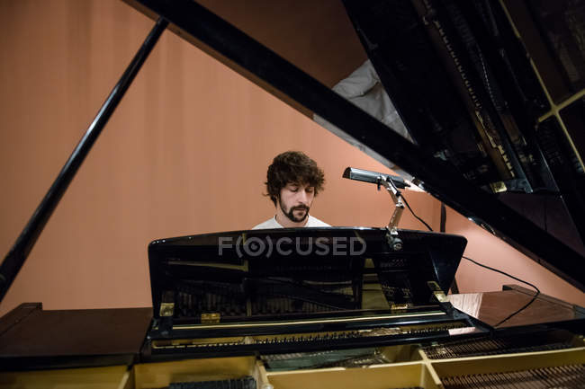 Homme jouant du piano en studio — Photo de stock