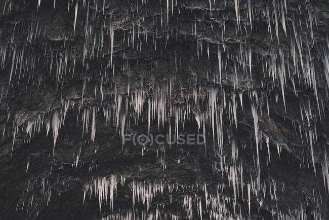 Замороженные сосульки на скале — стоковое фото