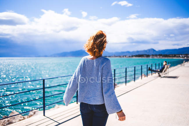 Femme marchant le long du front de mer — Photo de stock