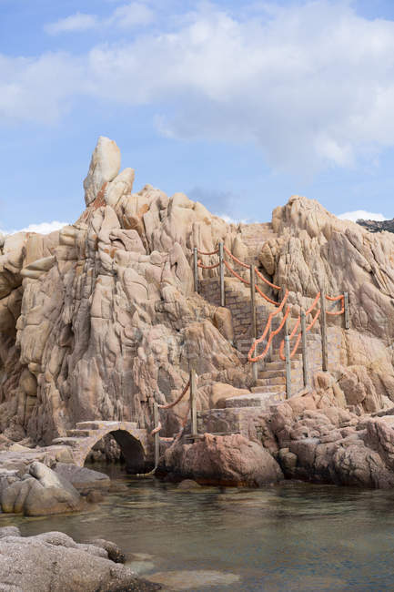 Puente y escaleras en la costa rocosa - foto de stock