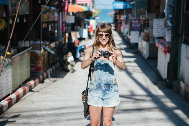 Frau mit Kamera steht auf Straße — Stockfoto