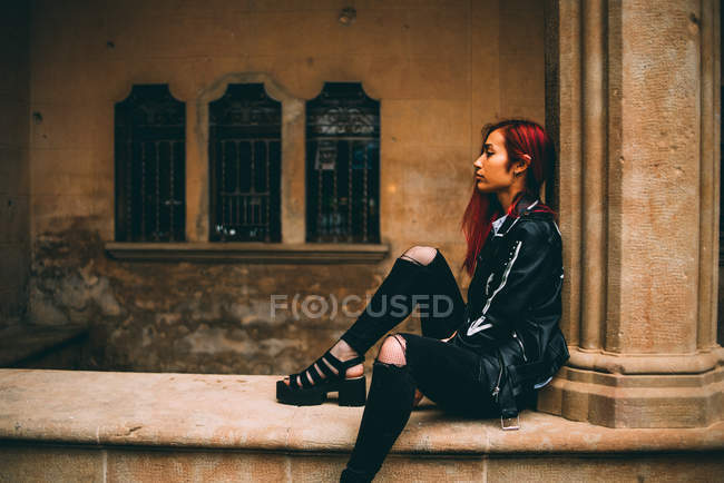 Woman sitting on old stone gallery — Stock Photo