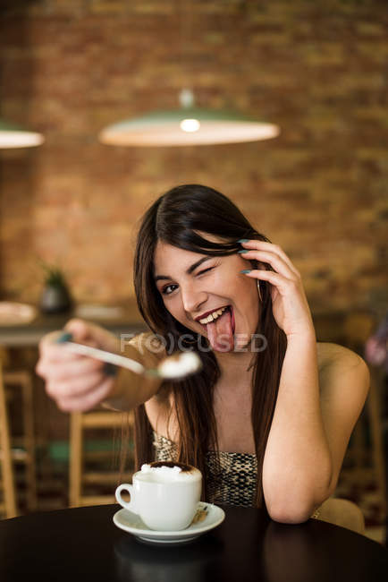 Женщина, сидящая в кафе и гримасничающая — стоковое фото