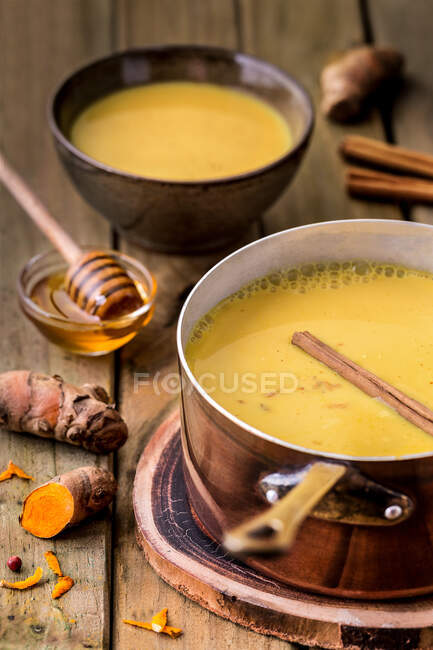 Topf voller appetitanregender gelber Suppe mit Honig auf Holztisch. — Stockfoto