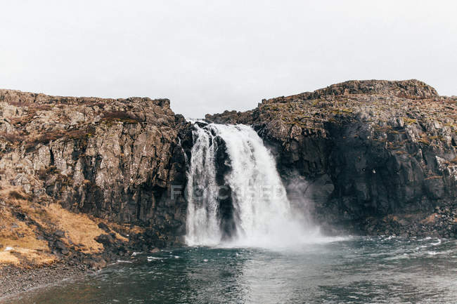 Водопад, падающий со скалистой скалы — стоковое фото
