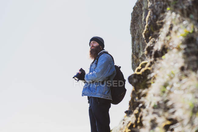 Homme avec caméra à côté de falaise — Photo de stock