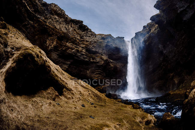 Водопад, текущий в скалах — стоковое фото