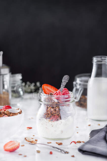 Vaso di vetro con gustosa colazione nutriente con muesli, panna e fragole. — Foto stock