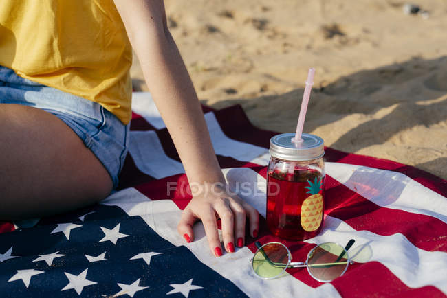 Chica sentada en la bandera americana - foto de stock