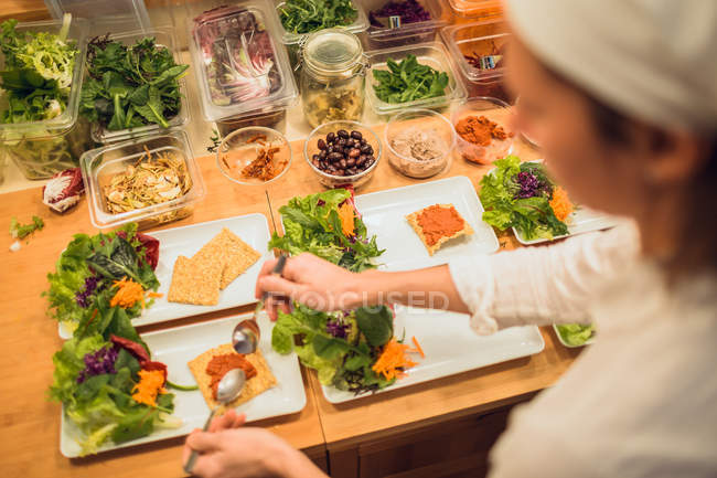 Frau serviert Teller mit veganen Snacks — Stockfoto