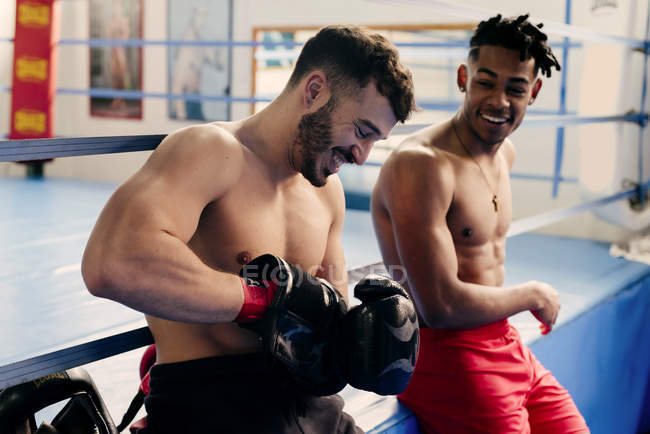 Muscular men putting on boxing gloves — Stock Photo
