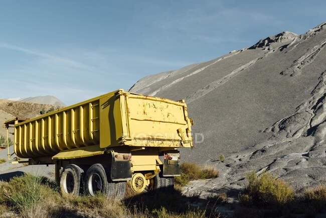 Old trailer abandoned close to a black gravel pile at a quarry — Stock Photo