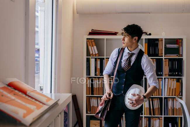 Bello giovane uomo guardando lontano in ufficio — Foto stock