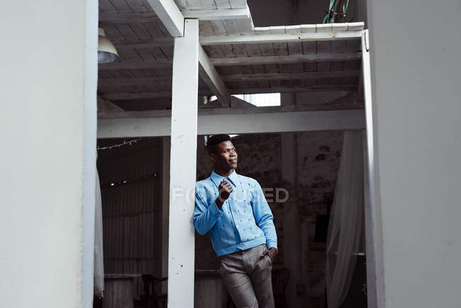 Чернокожий человек опирается на стену — стоковое фото