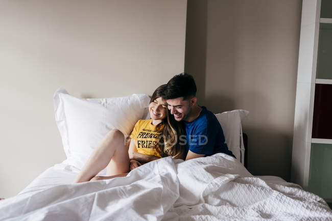 Улыбающаяся пара лежит в постели — стоковое фото