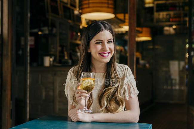 Женщина с напитком сидит в кафе — стоковое фото