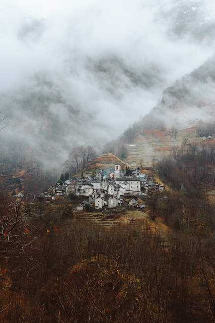 Small village on mountain in fog — Stock Photo