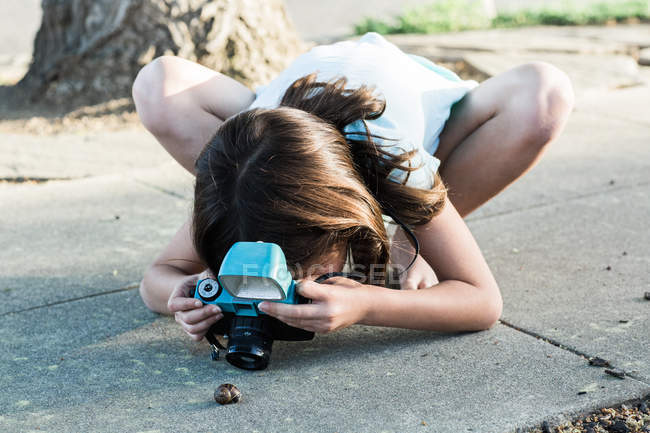 Girl shooting snail — Stock Photo