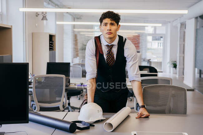 Young man with blueprint in office — Stock Photo