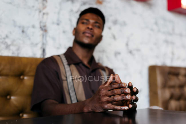 Черный человек кладет руки на стол — стоковое фото
