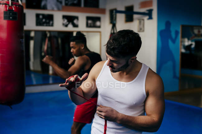 Fighter putting on bandage on hands — Stock Photo