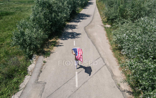Жінка вигулює з американським прапором — стокове фото