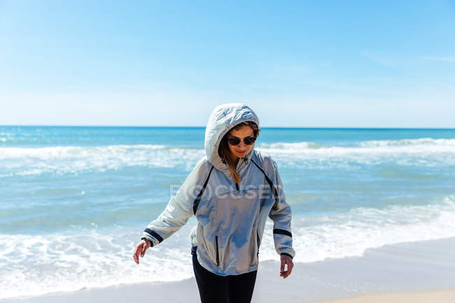Mulher de óculos andando na praia — Fotografia de Stock
