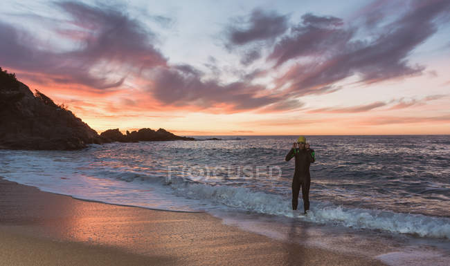 Triatleta caminando fuera del mar - foto de stock