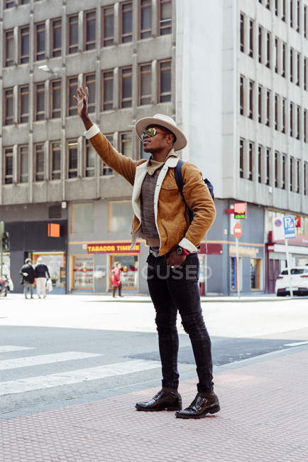 Hombre negro en gafas coger un taxi - foto de stock