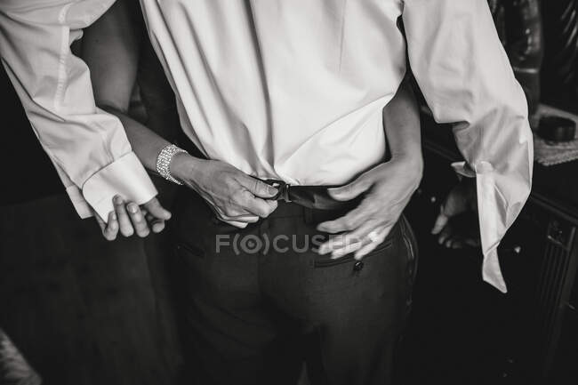 Tiro preto e branco de calças de abotoamento de mãos de homem elegante. — Fotografia de Stock
