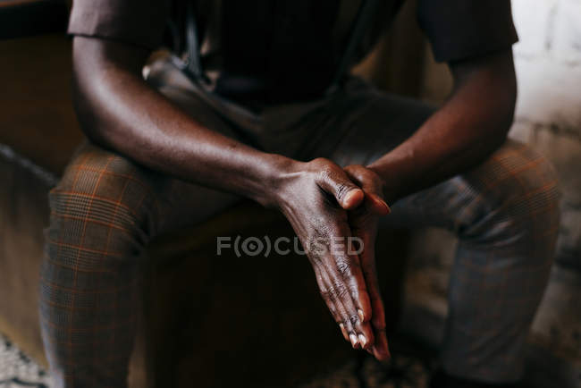Dobrar as mãos de sentado homem negro — Fotografia de Stock