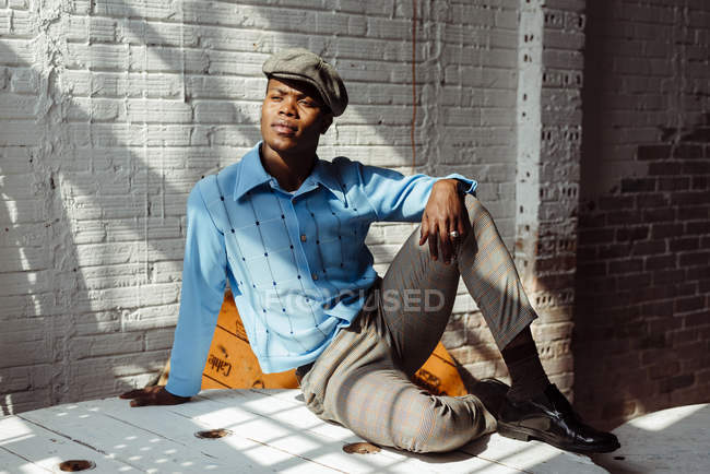 Stilvoller schwarzer Mann sitzt auf dem Boden — Stockfoto