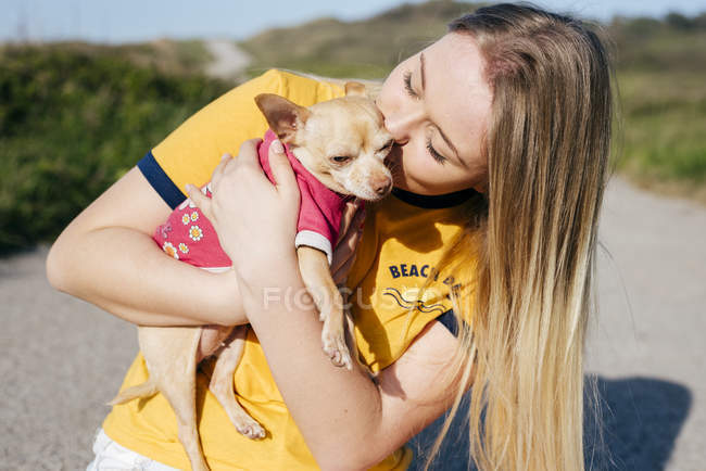 Chica besándose pequeña Chihuahua - foto de stock
