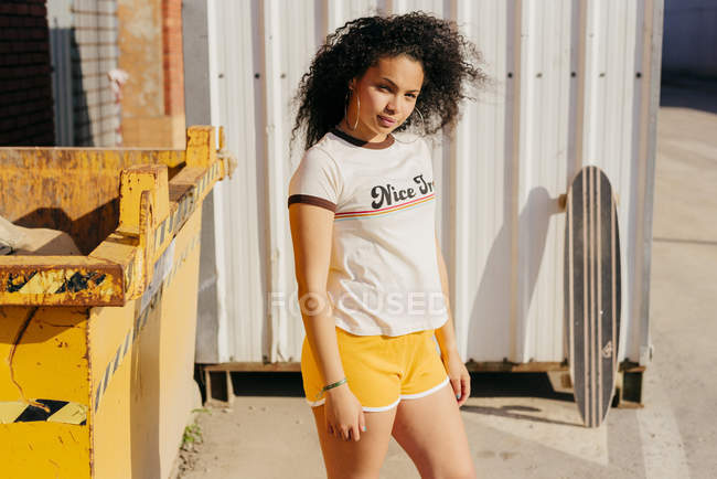 Female teenager standing near dumpster — Stock Photo