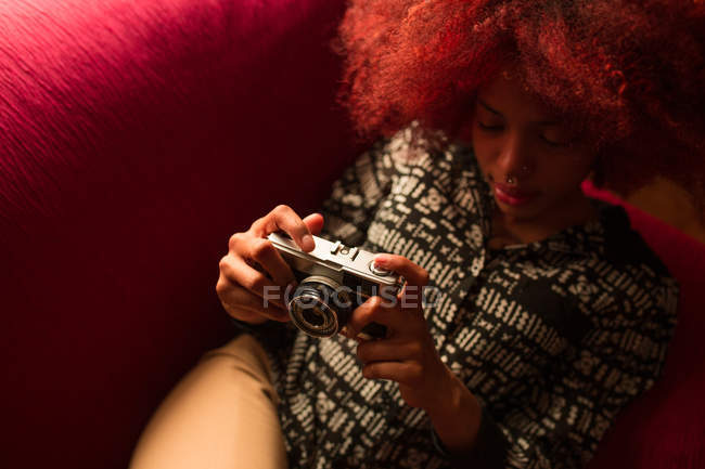 Mulher segurando câmera no sofá — Fotografia de Stock